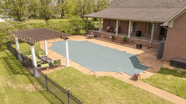 a view of a house with backyard and sitting area