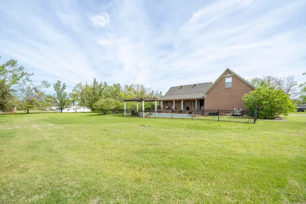 a front view of house with yard and trees in the background