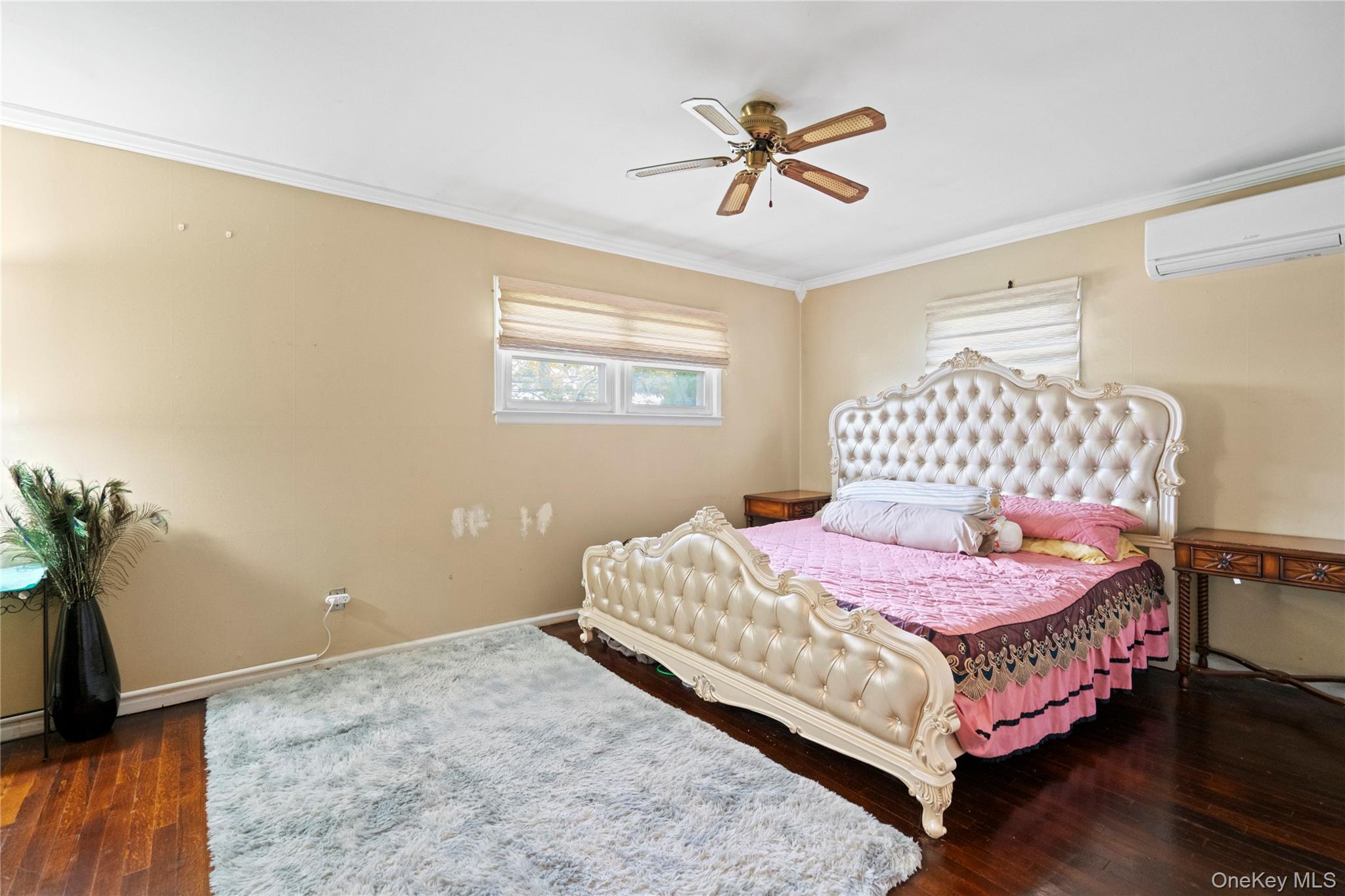 304 Unqua Road Massapequa, NY 11758 - Photo 12 of 26 a bedroom with a bed a chandelier and a dresser