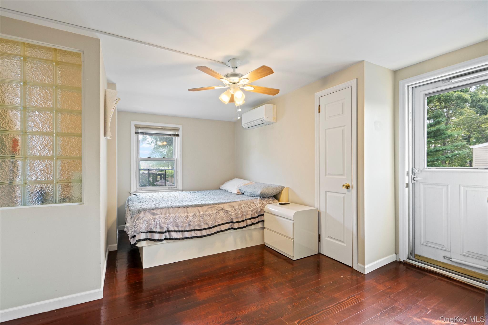 304 Unqua Road Massapequa, NY 11758 - Photo 19 of 26 a bedroom with a bed and a window with wooden floor