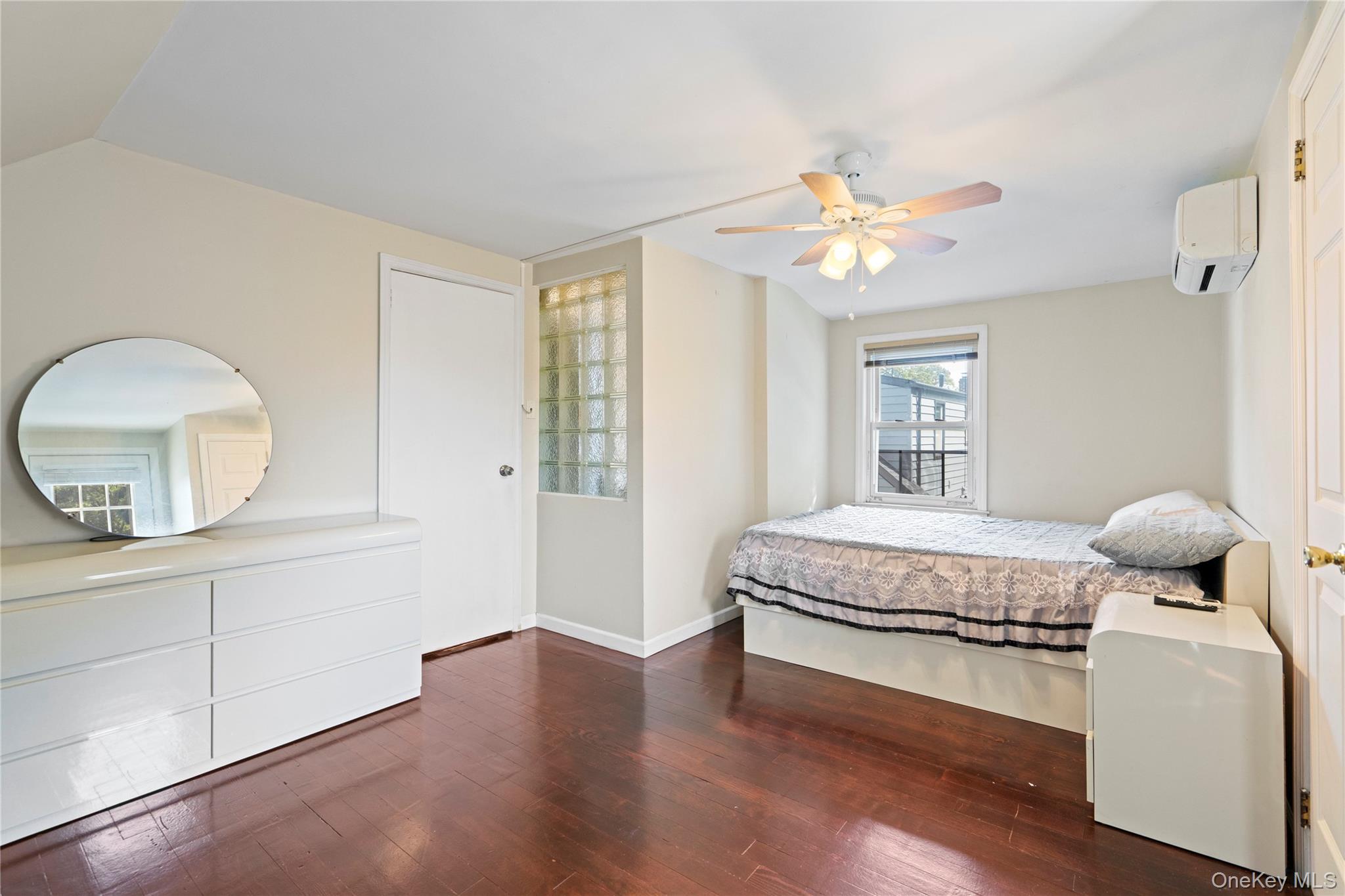 304 Unqua Road Massapequa, NY 11758 - Photo 21 of 26 a bedroom with a bed and a chandelier