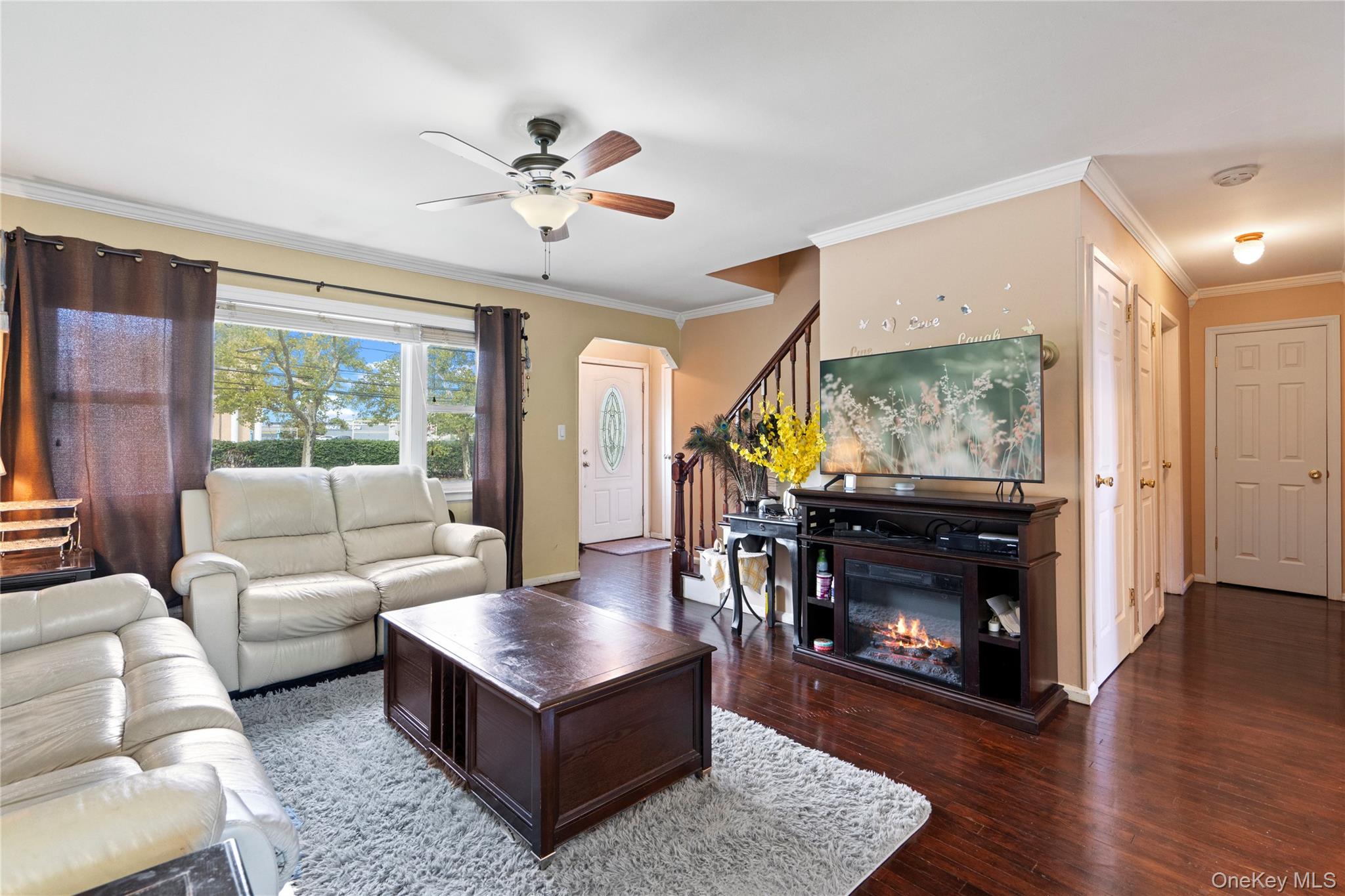304 Unqua Road Massapequa, NY 11758 - Photo 7 of 26 a living room with furniture a flat screen tv and a fireplace