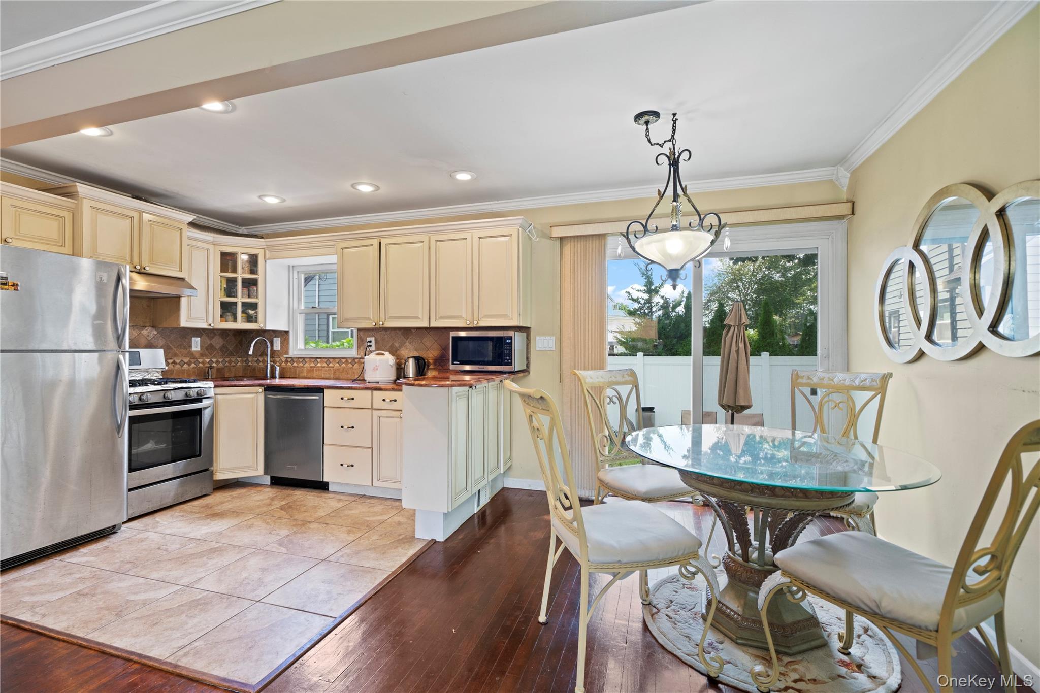 304 Unqua Road Massapequa, NY 11758 - Photo 8 of 26 a kitchen with refrigerator cabinets dining table and chairs