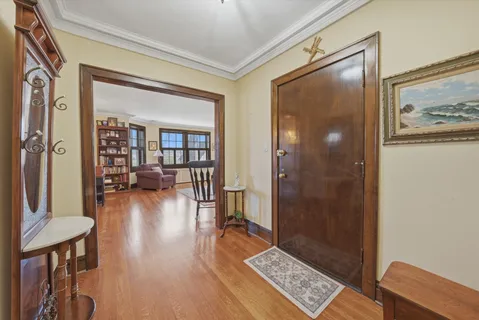 a kitchen with stainless steel appliances a dining table chairs and wooden floor