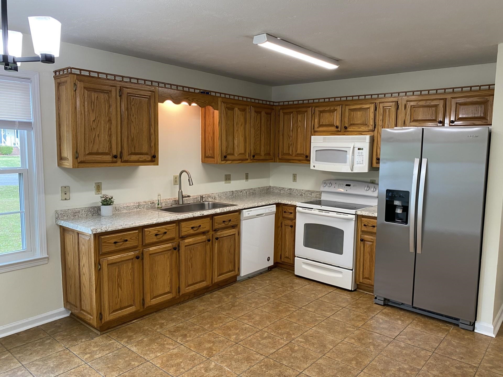 81 Candlewick Drive Jackson, TN 38305 - Photo 12 of 30 a white kitchen with stainless steel appliances granite countertop a stove a sink dishwasher a refrigerator and a microwave oven