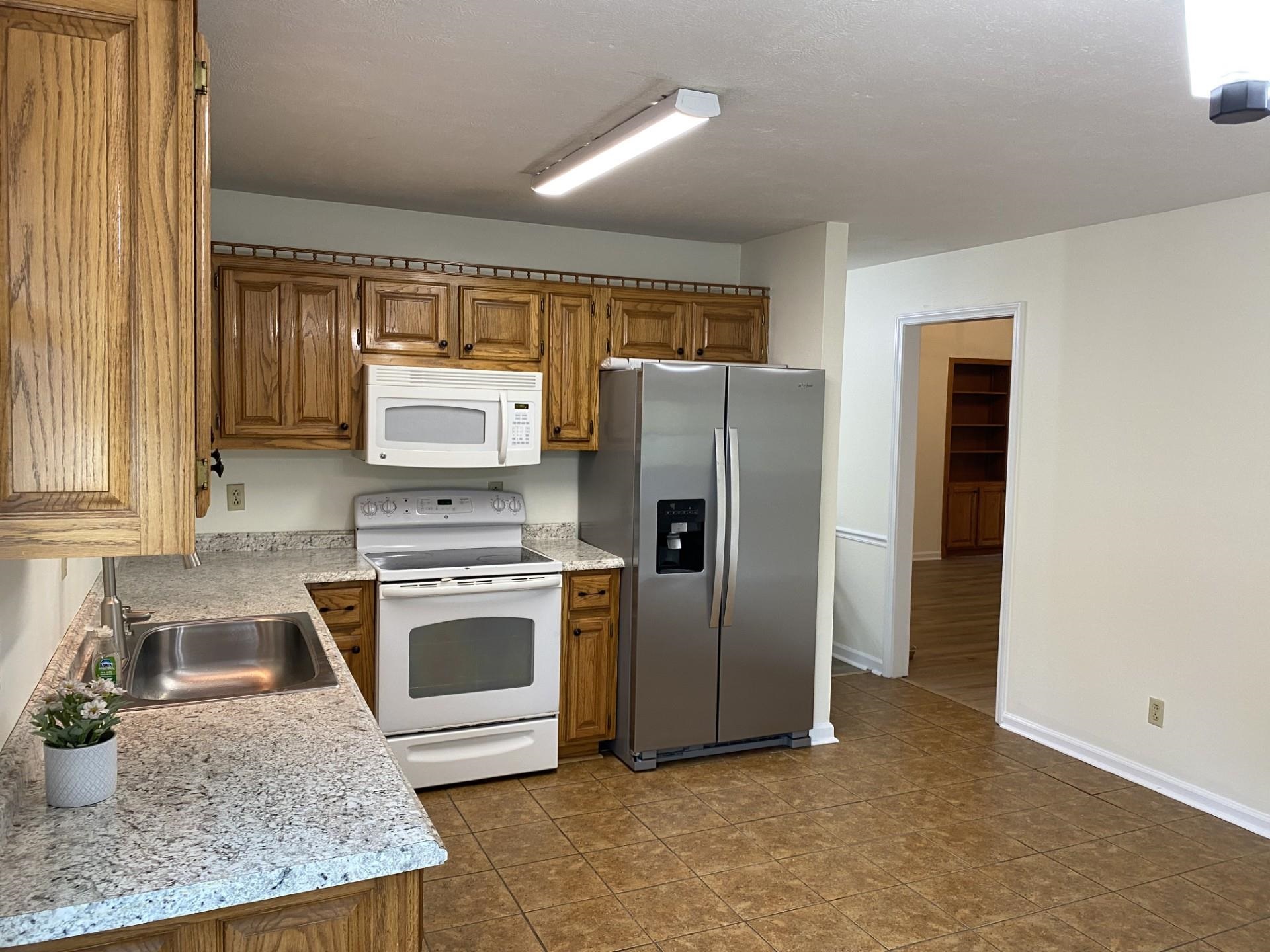 81 Candlewick Drive Jackson, TN 38305 - Photo 13 of 30 a kitchen with stainless steel appliances granite countertop a refrigerator a sink a stove and island