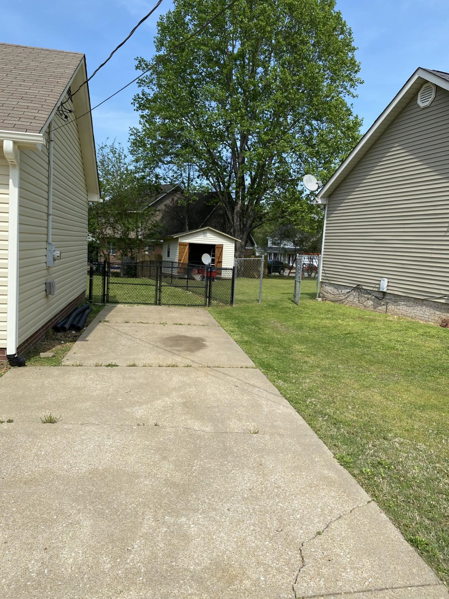 81 Candlewick Drive Jackson, TN 38305 - Photo 4 of 30 a backyard of a house with large trees and barbeque oven
