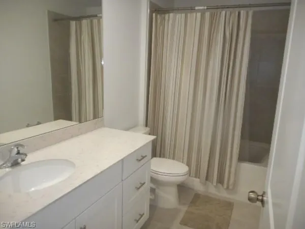 a bathroom with a sink a toilet and shower curtain