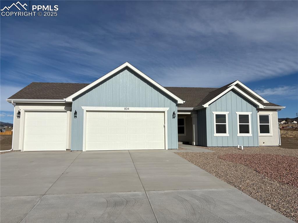 a view of house with garage and yard