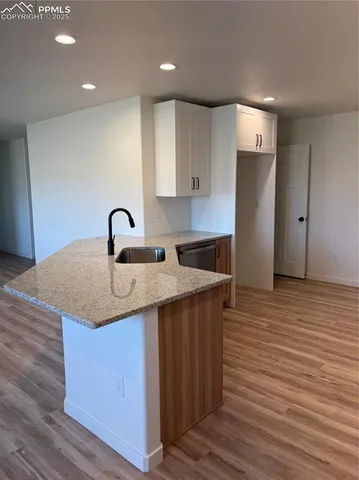 a kitchen with a sink cabinets and wooden floor