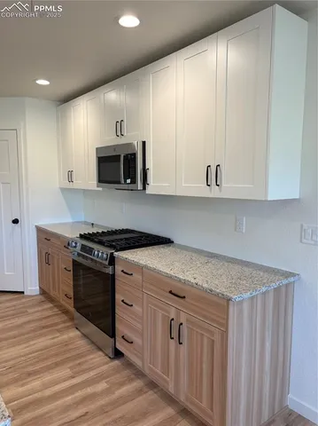 a kitchen with stainless steel appliances granite countertop a stove a sink and a microwave