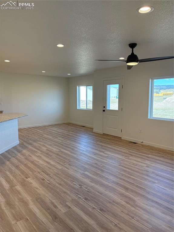 834 Keystone Loop Canon City, CO 81212 - Photo 7 of 22 an empty room with wooden floor ceiling fan and windows