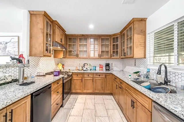 a kitchen with stainless steel appliances granite countertop a sink stove and cabinets