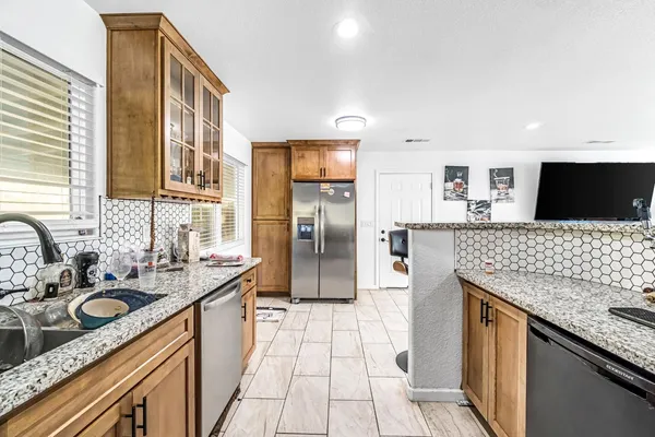 a kitchen with stainless steel appliances granite countertop a sink stove and refrigerator