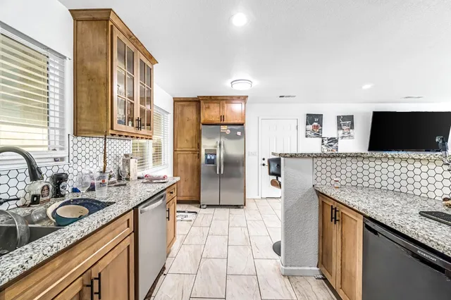 a kitchen with stainless steel appliances granite countertop a sink stove and refrigerator