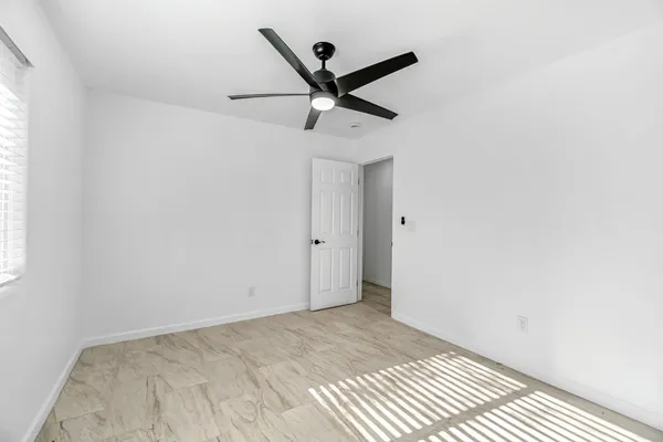a view of a room with a ceiling fan and wooden floor
