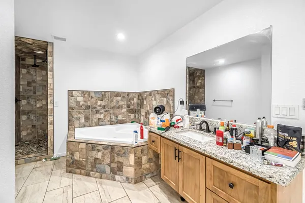 a bathroom with a bathtub sink and a mirror