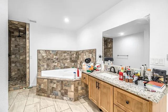 a bathroom with a bathtub sink and a mirror