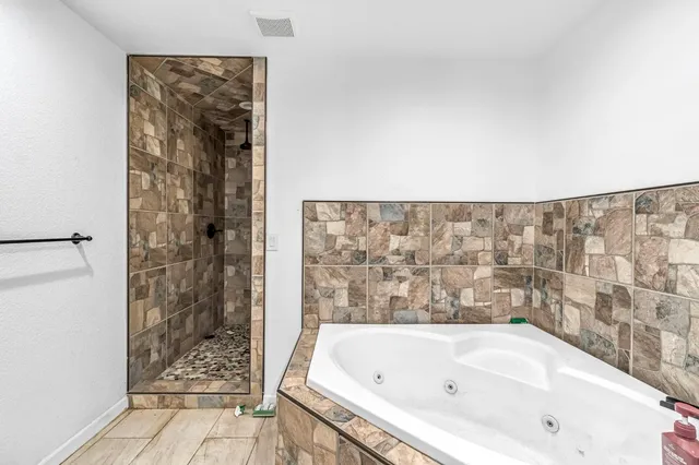 a bathroom with a bathtub and shower