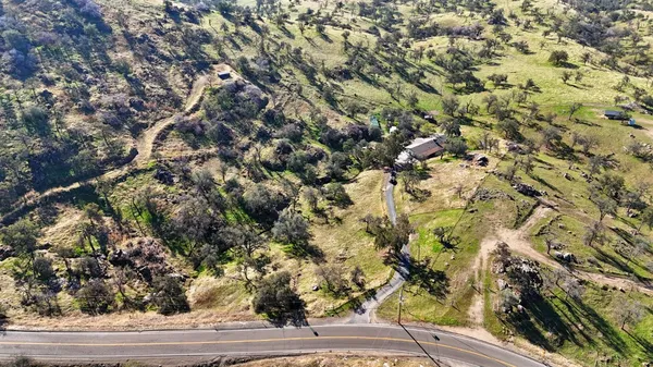 an aerial view of a house with a mountain