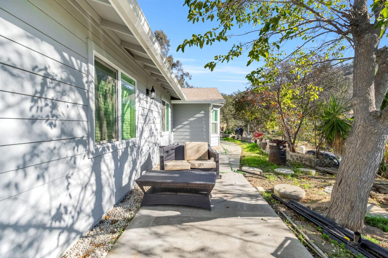 34045 George Smith Road Squaw Valley, CA 93675 - Photo 7 of 37 a view of a patio with couches table and chairs with wooden fence and large trees