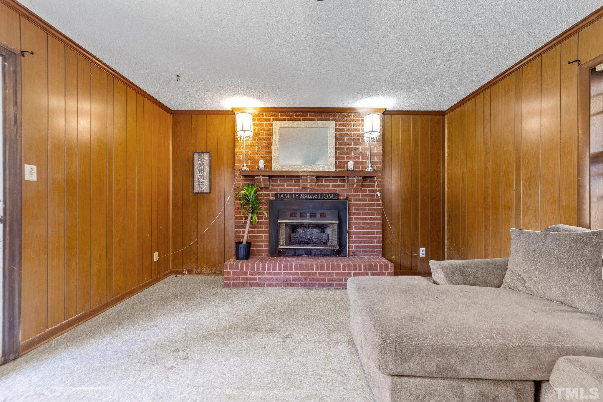 801 Avalon Road Durham, NC 27704 - Photo 16 of 30 a living room with furniture a fireplace and a flat screen tv