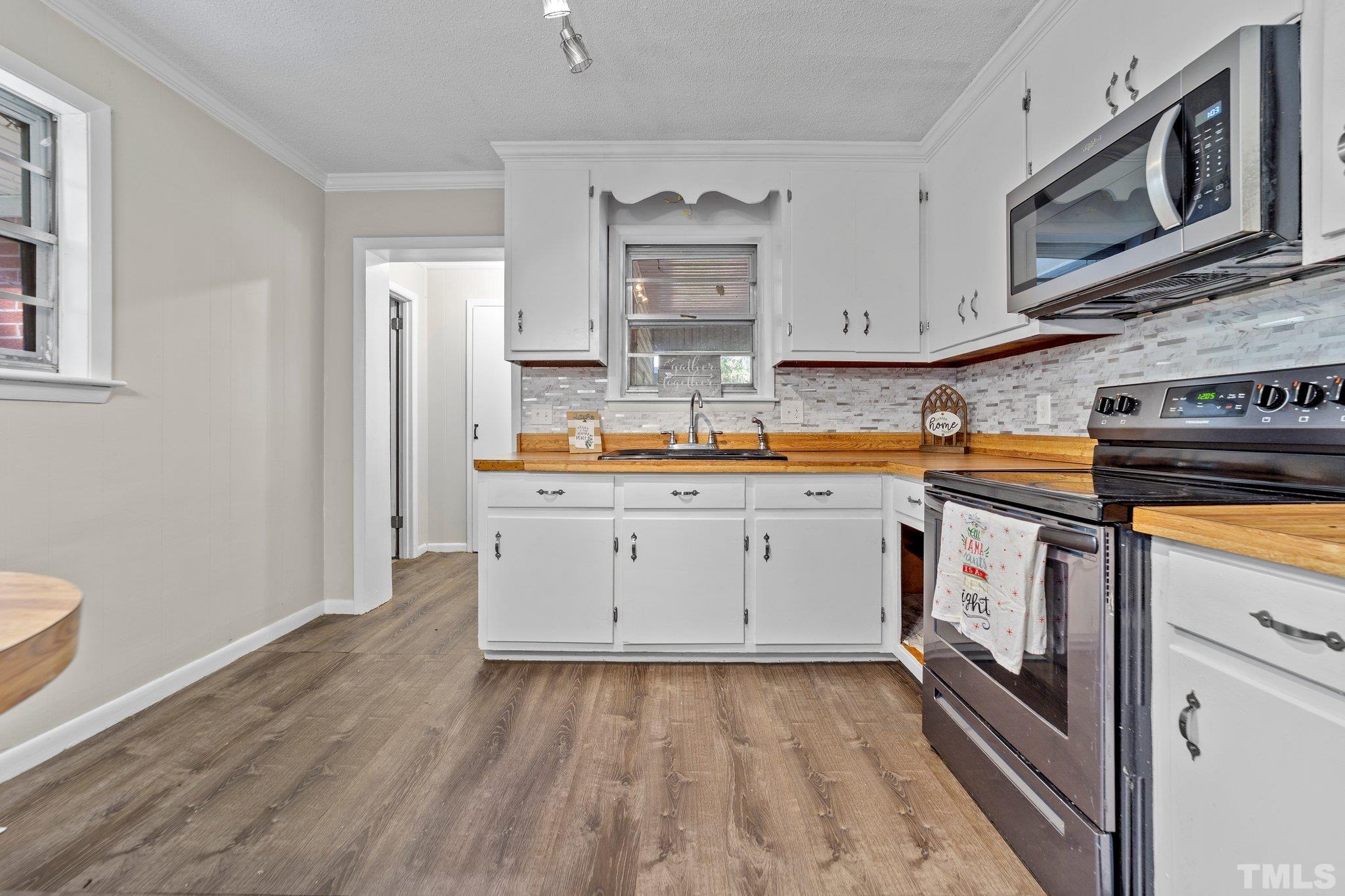 801 Avalon Road Durham, NC 27704 - Photo 18 of 30 a kitchen with stainless steel appliances granite countertop a stove a sink and a microwave