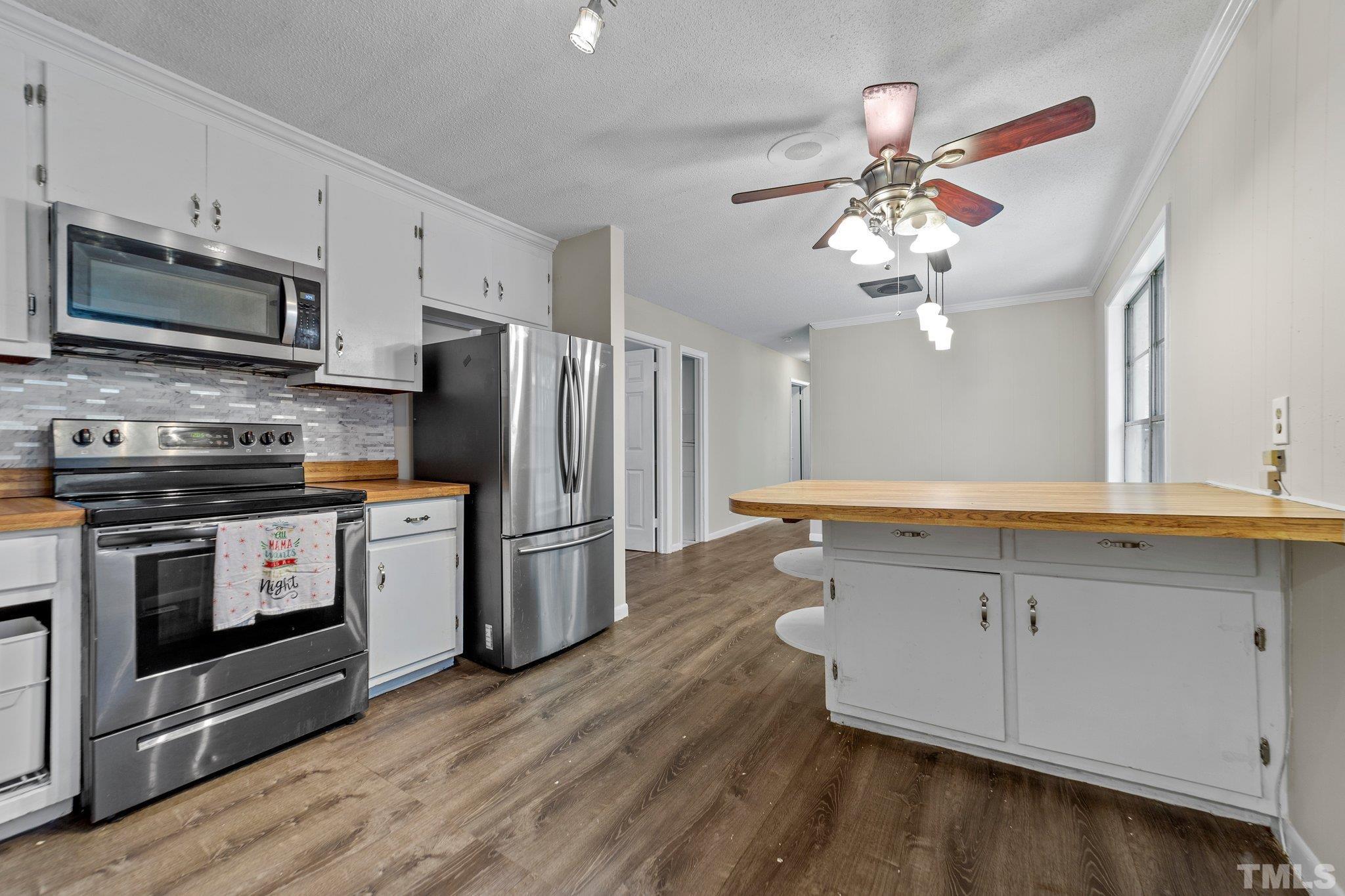 801 Avalon Road Durham, NC 27704 - Photo 19 of 30 a kitchen with stainless steel appliances a stove refrigerator and microwave