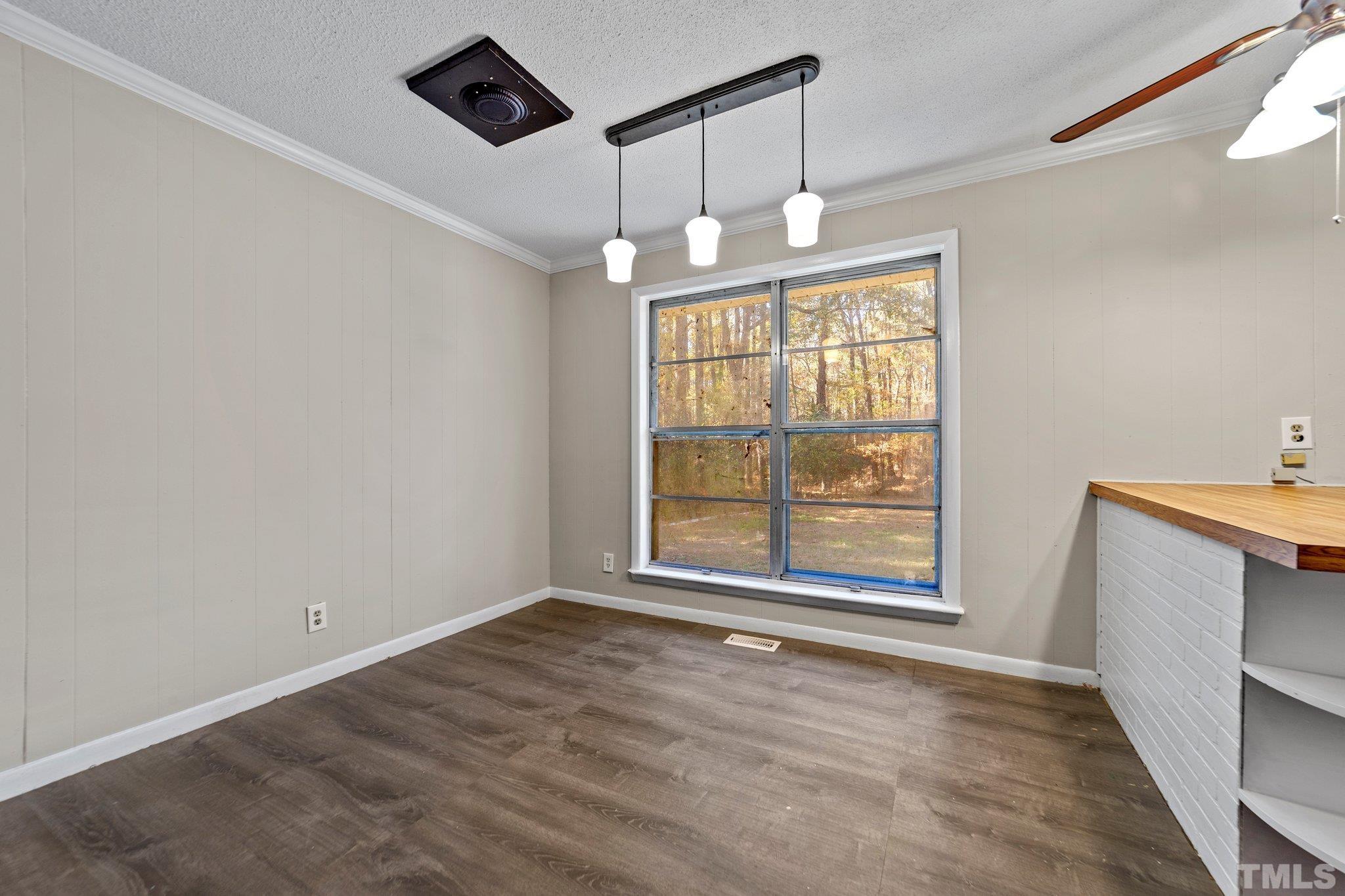 801 Avalon Road Durham, NC 27704 - Photo 20 of 30 an empty room with chandelier fan and windows