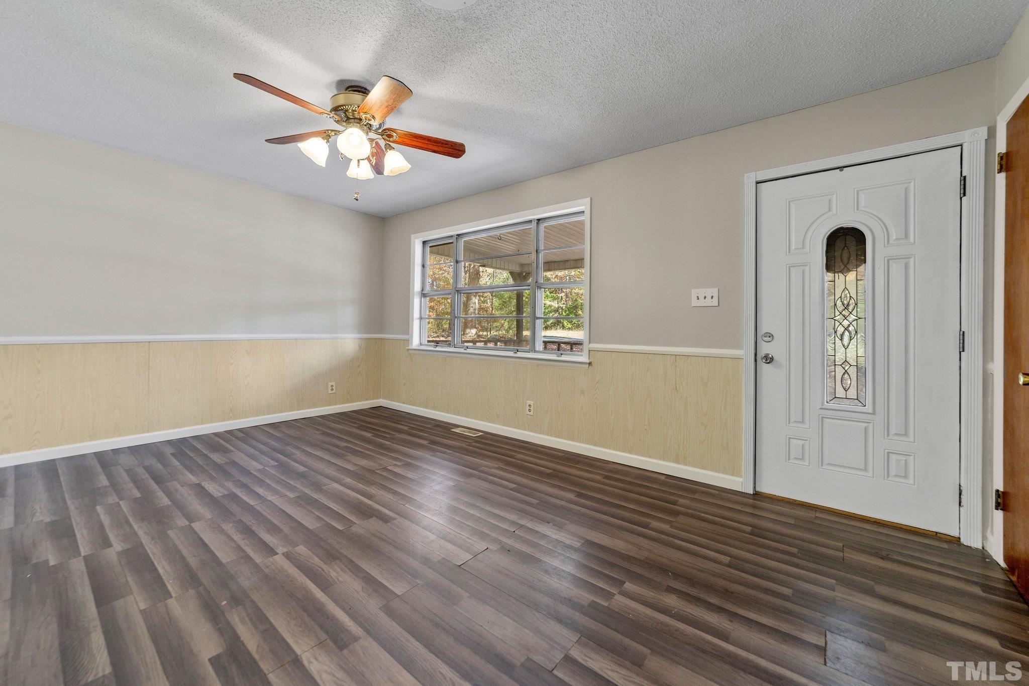 801 Avalon Road Durham, NC 27704 - Photo 22 of 30 an empty room with wooden floor chandelier fan and windows