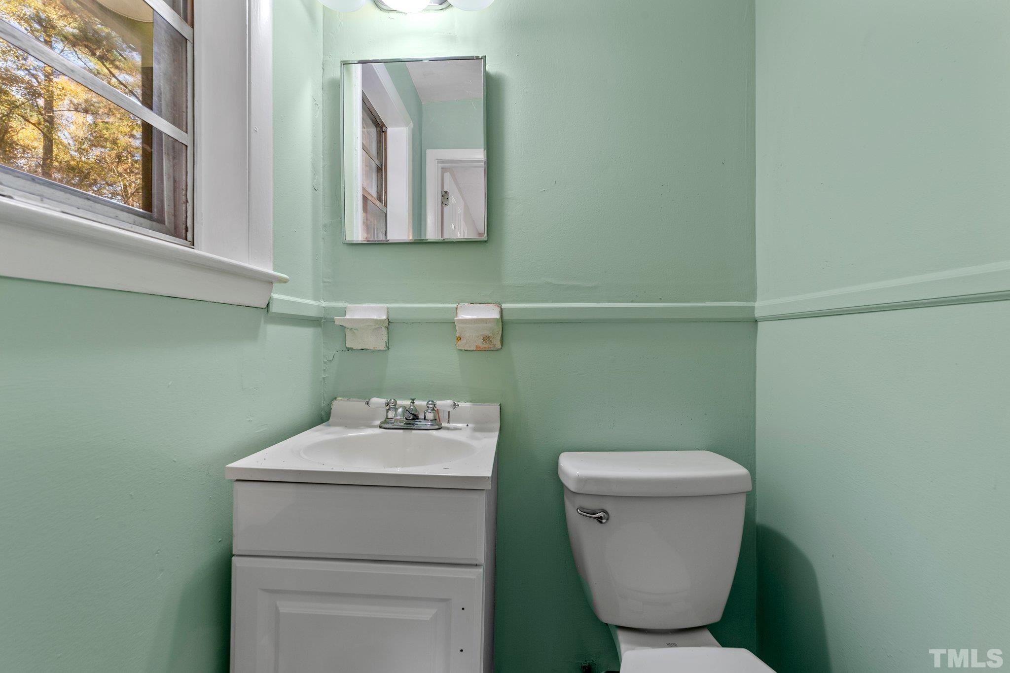 801 Avalon Road Durham, NC 27704 - Photo 29 of 30 a bathroom with a toilet sink and mirror
