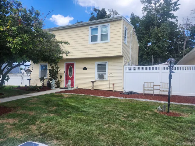 a view of a white house and a yard with a fountain