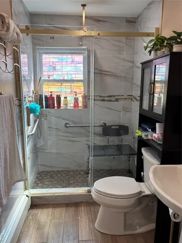 a bathroom with a toilet a sink and a shower