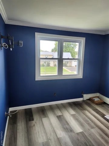 an empty room with wooden floor and mirror