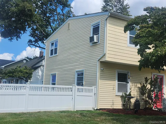 a view of house with a yard and a large tree