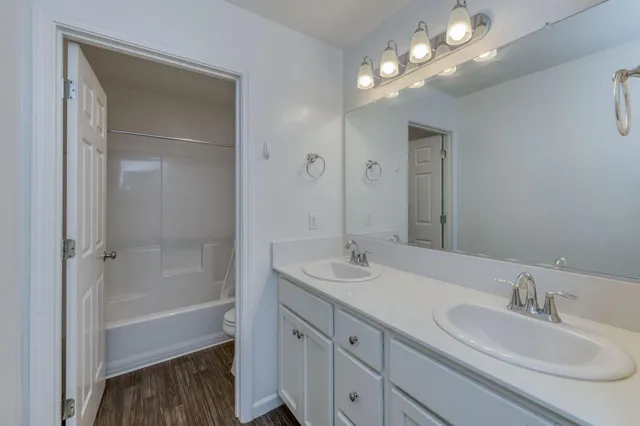 a bathroom with a sink double vanity granite tub and shower