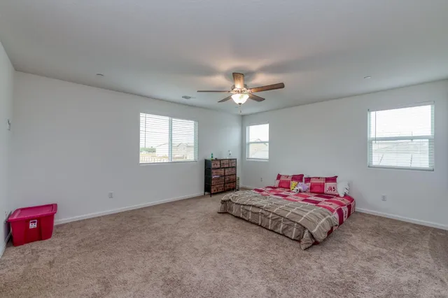 a spacious bedroom with a bed and a chandelier
