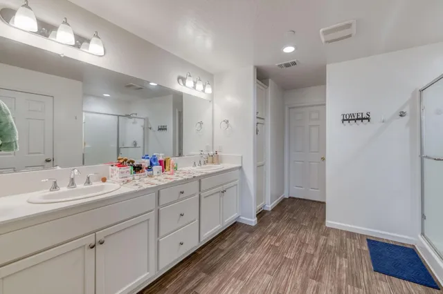 a bathroom with a double vanity sink mirror and shower