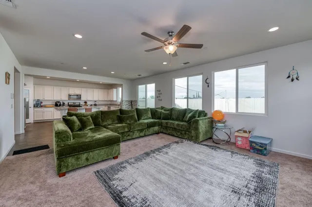 a living room with furniture kitchen view and a window