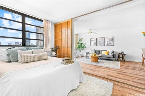a spacious bedroom with a bed a couch and a large window