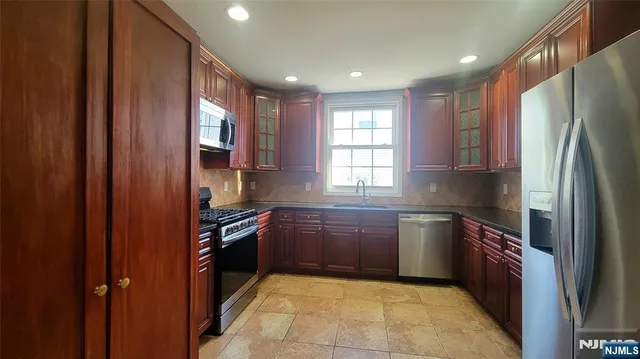 a kitchen with stainless steel appliances granite countertop a refrigerator and a sink