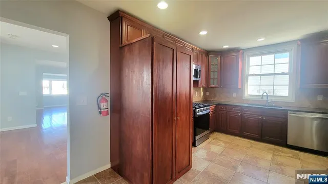 a kitchen with stainless steel appliances granite countertop a refrigerator and a sink