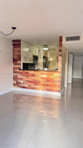 a view of empty room with kitchen