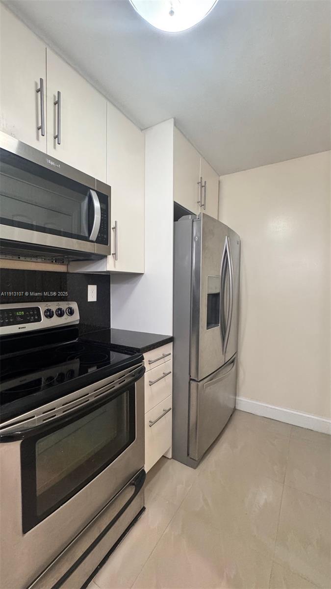 15610 Southwest 80th Street, Unit J104 Miami, FL 33193 - Photo 5 of 16 a kitchen with appliances and cabinets