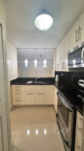 a large white kitchen with a stove a microwave and a refrigerator