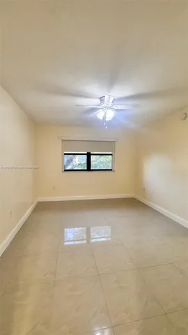 en empty room with windows and chandelier