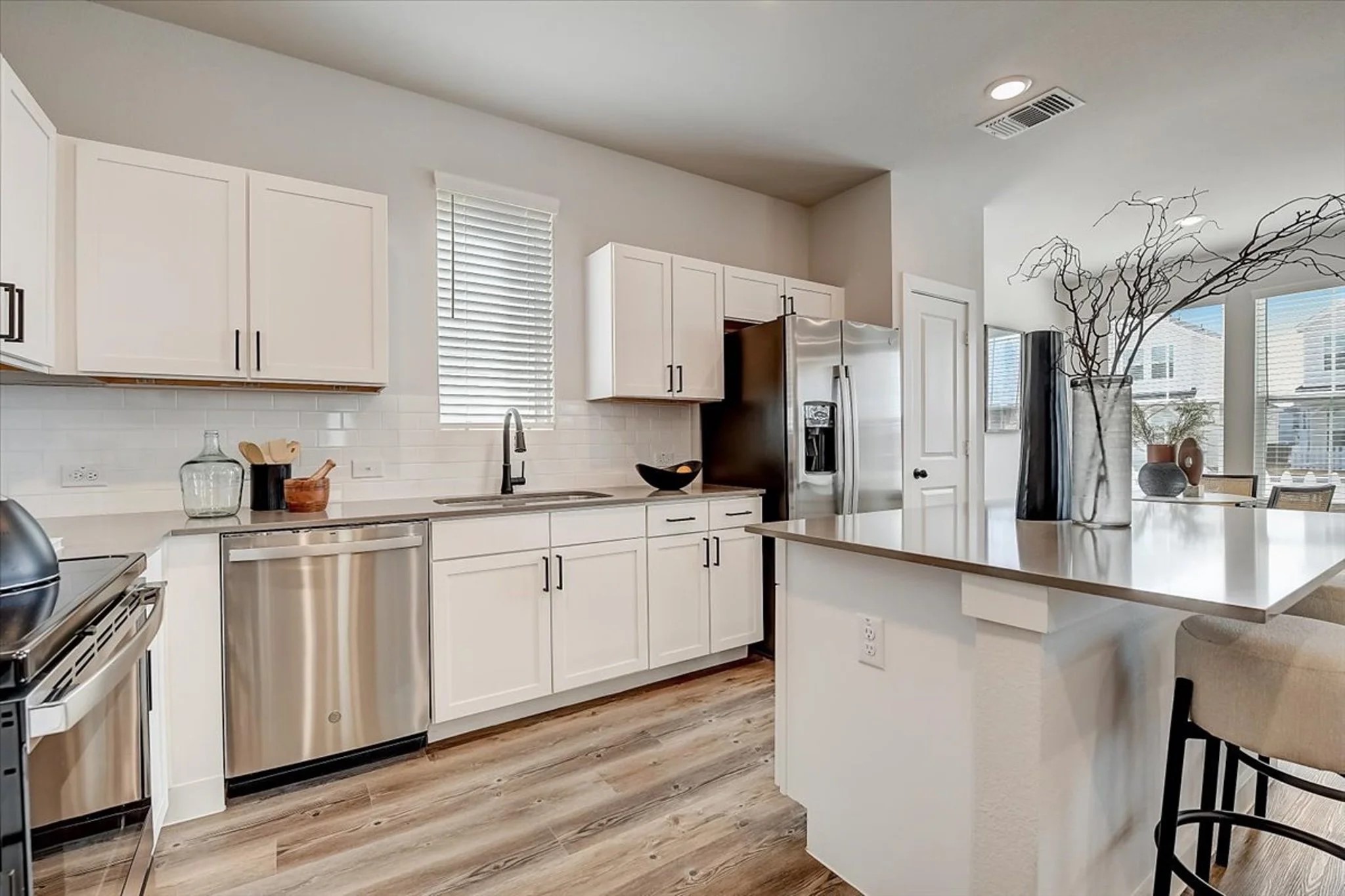 15101 Litsey Crk Drive, Unit 15259H Roanoke, TX 76262 - Photo 6 of 20 a large kitchen with stainless steel appliances granite countertop a stove a sink dishwasher and a refrigerator with wooden floor