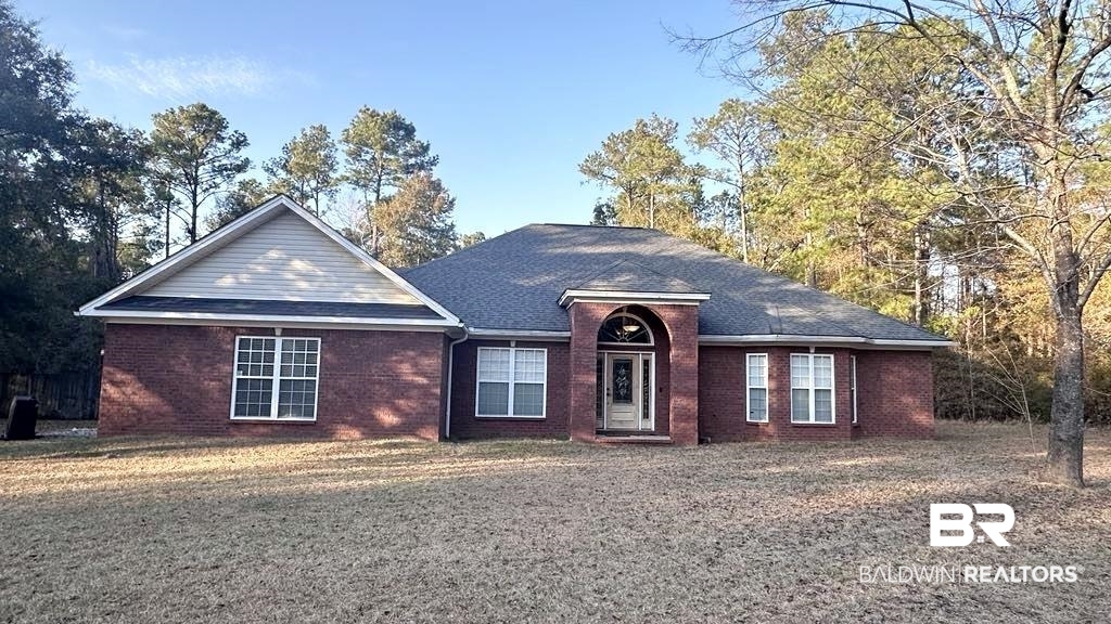 23289 McPhillips Road Loxley, AL 36551 - Photo 17 of 19 Brick exterior residence featuring a prominent entryway with an arched portico and glass-paneled door