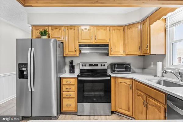 a kitchen with stainless steel appliances granite countertop a sink and a stove
