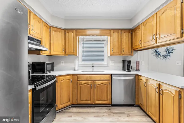 a kitchen with stainless steel appliances granite countertop a refrigerator stove top oven and sink